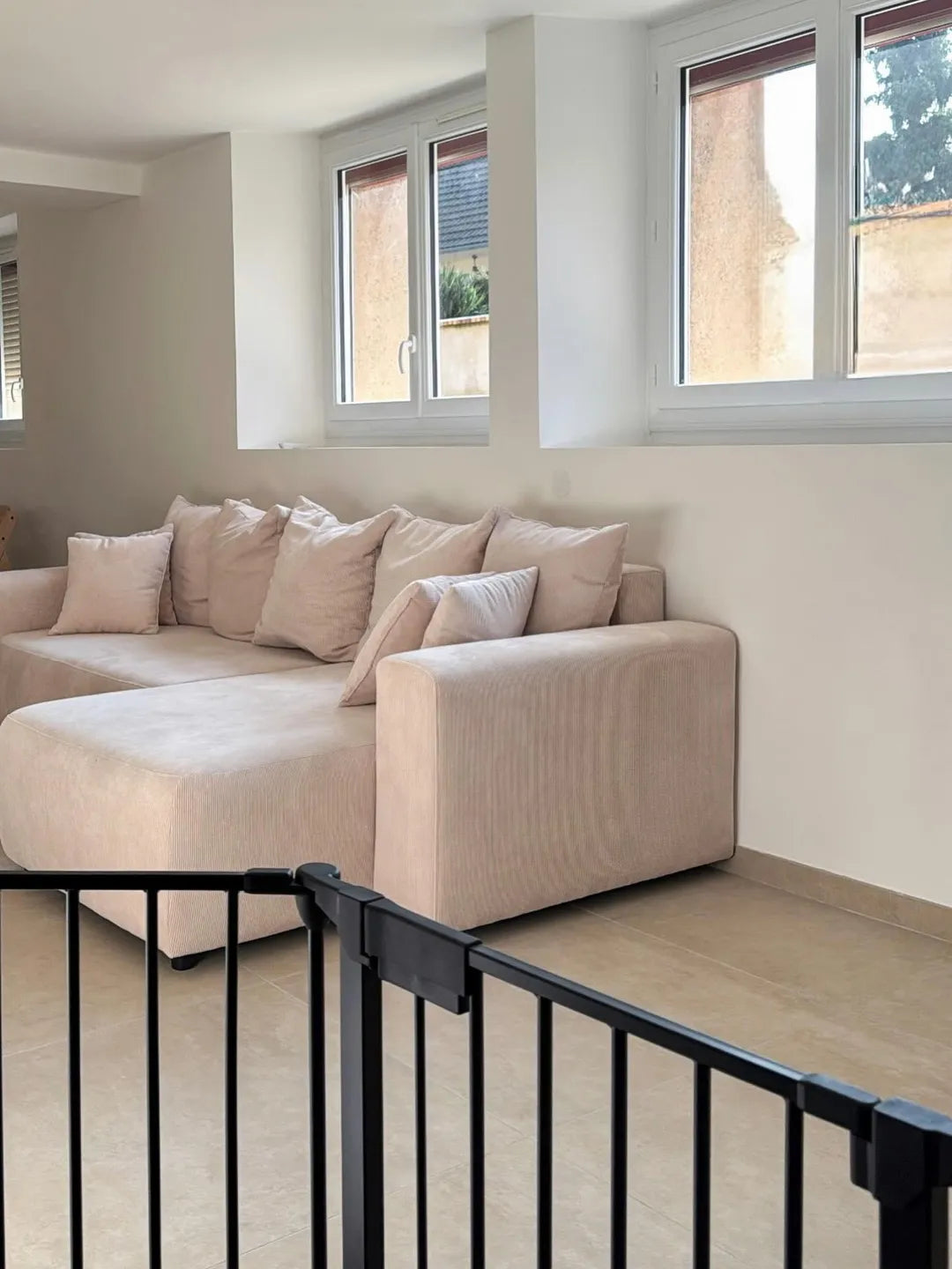 Canapé d’angle beige en velours côtelé dans un salon lumineux