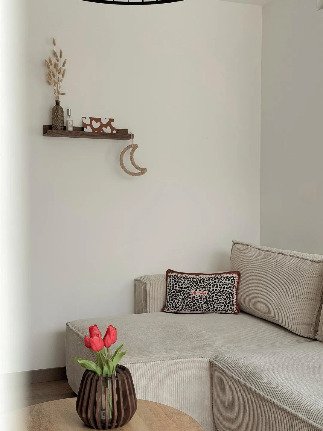 Méridienne beige en velours côtelé avec coussin et tulipes sur la table basse